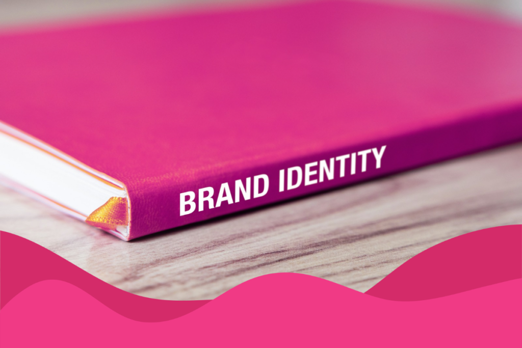 Image of a pink book with 'BRAND IDENTITY' written in bold white on the spine on a wooden table in an article about the importance of brand awareness and consistency across Google, social media, and AI search by Daffodil Marketing in Sheffield, South Yorkshire.